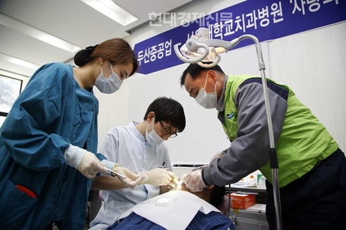 서울대치과병원 의료진이 두산중공업 자원봉사자)와 함께 사내협력사직원을 대상으로 치과 진료하고 있다.