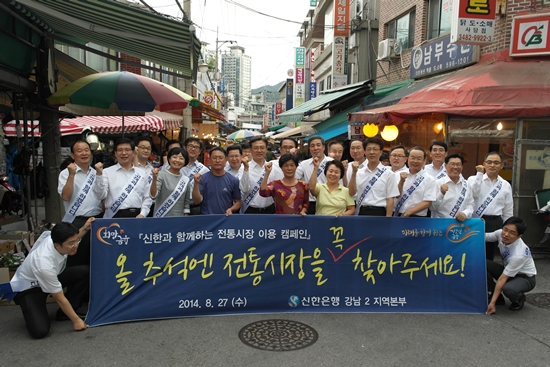 김영표 신한은행 부행장(앞줄 왼쪽 다섯번째)이 임직원들과 함께 서울 동작구 사당동의 남성시장에서 전통시장 이용 캠페인을 진행하고, 시장상인들과 기념촬영을 하고 있다.