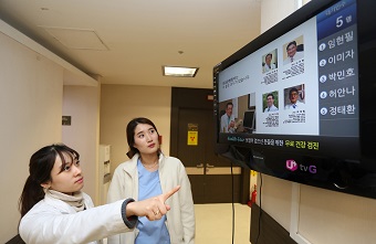 서울시 강남구의 한 병원에서 간호사들이 ‘U+Biz tvG 스마트 솔루션’ 서비스를 적용한 TV화면으로 진료 대기표를 보고 있다. <사진=LG유플러스 제공>