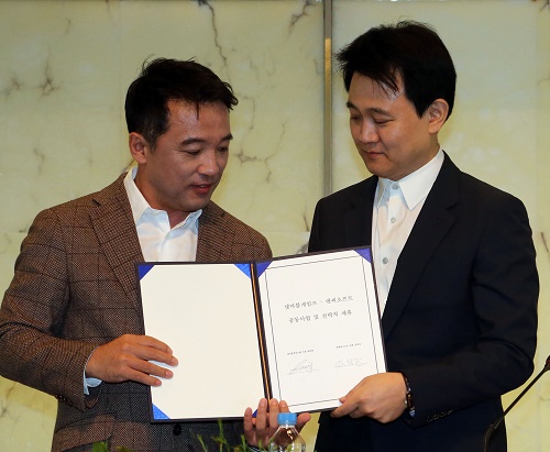 김택진 엔씨소프트 대표(왼쪽)과 방준혁 넷마블게임즈 의장이 17일 서울 중구 플라자호텔에서 열린 공동사업 및 전략적 제휴식에서 협약서를 들어보이고 있다.