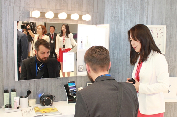 2015 MWC에서 LG유플러스 직원이 외국인 관람객에 매직미러 서비스를 소개하고 있다. <사진=LG유플러스 제공>