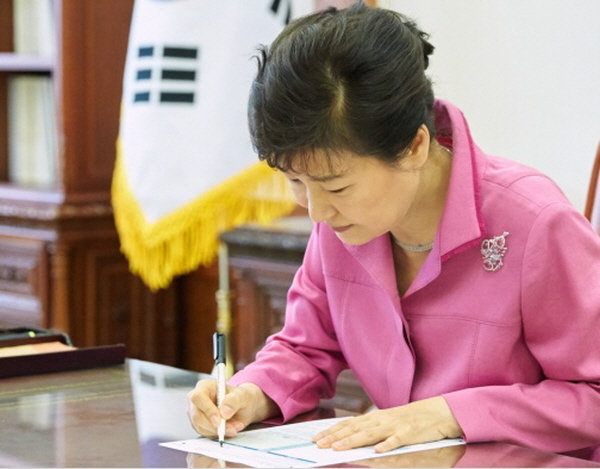 박근혜 대통령이 21일 오전 청와대 본관에서 대통령주재 수석비서관회의 종료 직후 KEB하나은행의 청년희망펀드 공익신탁 가입신청서에 서명을 하고 있다.<사진=청와대>