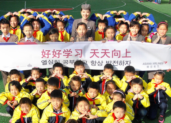 3일 아시아나항공 승무원과 중국 장쑤성 우시시 창안난후씨앙소학교 학생들이 아시아나항공 승무원이 아름다운교실 자매결연식 후 기념촬영을 하고 있다. <사진=아시아나항공>