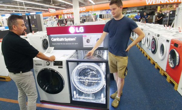 독일 베를린 시내의 가전매장을 찾은 고객들이 저진동, 고효율을 구현한 '센텀 시스템'을 적용한 드럼세탁기를 둘러보고 있다. <사진=LG전자>