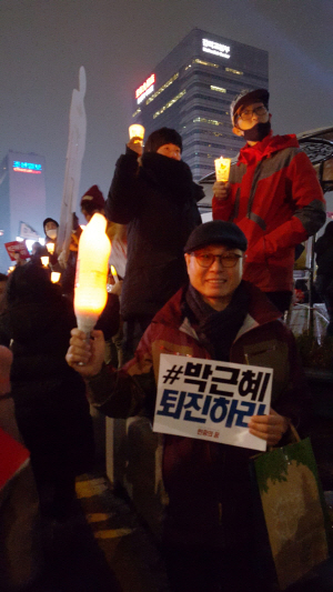 이근천씨가 자신이 만든 촛불을 들고 박근혜 정권 퇴진을 외치고 있다. <사진=민경미 기자>