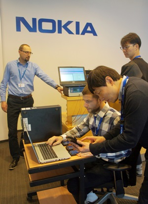 SK텔레콤과 노키아의 구성원들이 폴란드 크라쿠프에 위치한 노키아 연구소에서 세계 최초로 VoLTE망 기반의 차세대 무전통신 기술을 시연하고 있다. <사진=SK텔레콤>