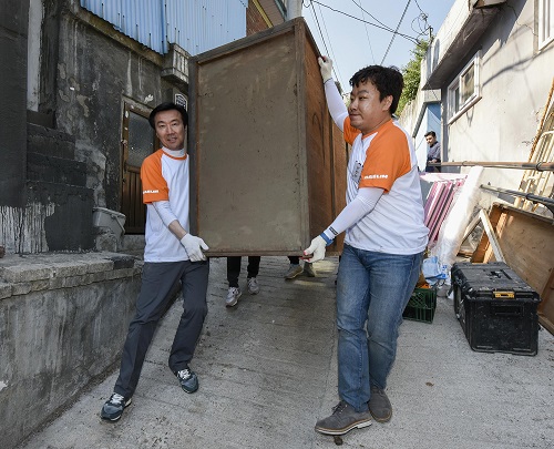 김한기 대림산업 사장(왼쪽)이 희망의 집고치기 봉사활동을 하며 집안의 가구를 옮기고 있다. <사진=대림산업>