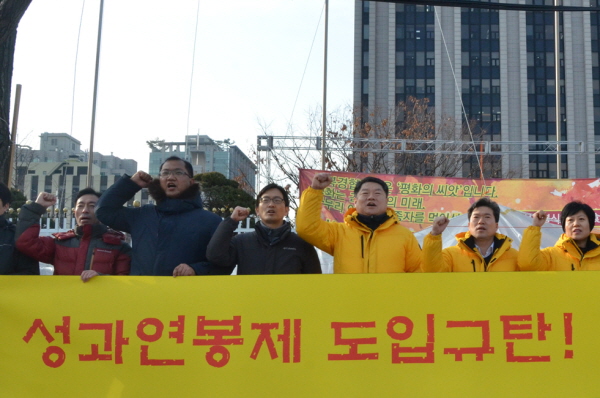 지난해 12월 12일 금융노조 노조원들이 금융위원회 앞에서 성과연봉제 도입 반대 규탄대회를 가지고 있는 모습.