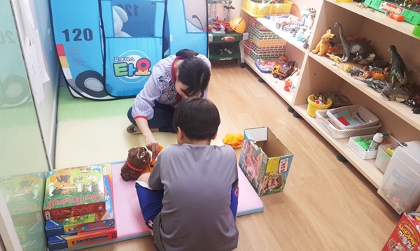 ‘토닥토닥 마음교실‘에서 어린이가 놀이치료사에게 놀이치료를 받고 있다. <사진=웹젠>