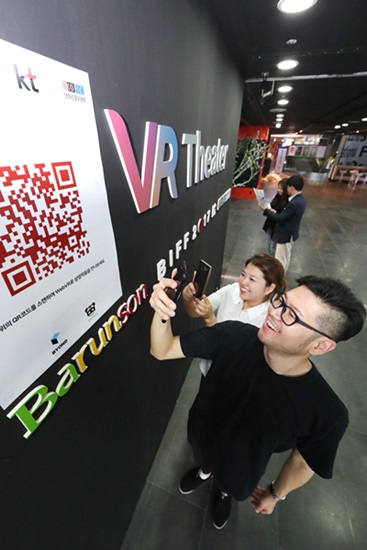 관람객들이 극장 외부에서 VR영화를 감상하기 위해 영화의 전당에 비치된 QR코드를 사용하고 있다.<사진=KT>