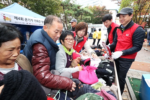 KT그룹 임직원 봉사단이 동자동 쪽방촌 주민과 함께 방한복을 고르고 있다. <사진=KT>