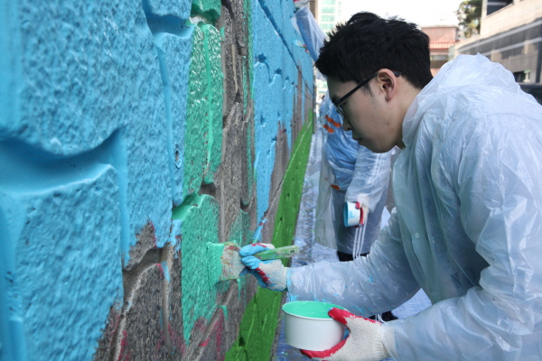동아쏘시오그룹 직원들이 9일 서울 동대문구 휘경동 회기역 주변에서 벽화그리기 봉사활동을 하고 있다. 