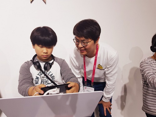 김홍규 신사업 부사장이 ‘세븐나이츠2’ 부스에서 초등학생 유저와 게임에 대해 소통하고 있다. <사진=유성현 기자>