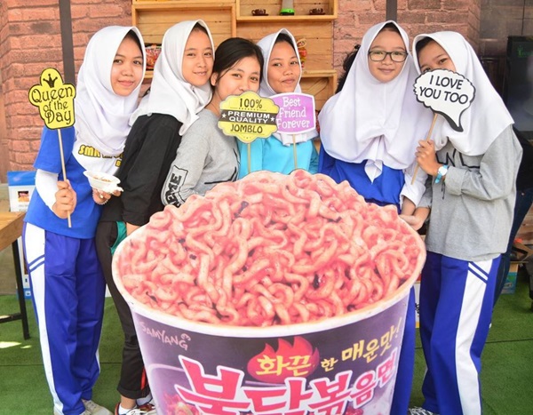 인도네시아 자카르타 인근 지역 중고등학교에서 진행된 ‘School Road Show’에서 소비자들이 불닭볶음면 모형과 함께 기념사진을 촬영하고 있다. <사진=삼양식품>