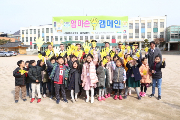KB손해보험 ‘엄마손캠페인’에 참여한 어린이들이 서울 재동초등학교에서 보행안전수칙을 학습한 뒤 캠페인 관계자들과 함께 기념사진을 찍고 있다.<사진=KB손해보험>