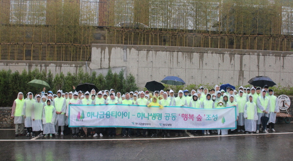 하나생명·하나금융티아이 임직원들이 12일 서울 상암동 하늘공원에서 나무심기 사회공헌 활동을 실시 한 후 기념사진을 찍고 있다.<사진=하나생명>