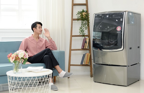 LG전자 모델이 LG 트롬 씽큐 드럼세탁기에 말을 걸고있다. <사진=LG전자>