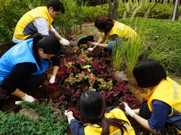 CJ헬스케어·한국콜마 임직원들이 18일 서울 서초구 내곡동에 있는 서울시 어린이병원에서 정원을 만들고 있다. 