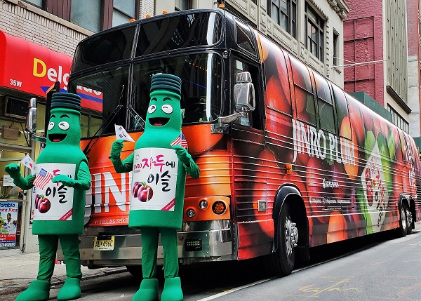 지난 6일 뉴욕 맨해튼에서 열린 한인축제 퍼레이드에 함께한 자두에이슬 병돌이가 자두에이슬 홍보버스 앞에서 포즈를 취하고 있다. <사진=하이트진로>