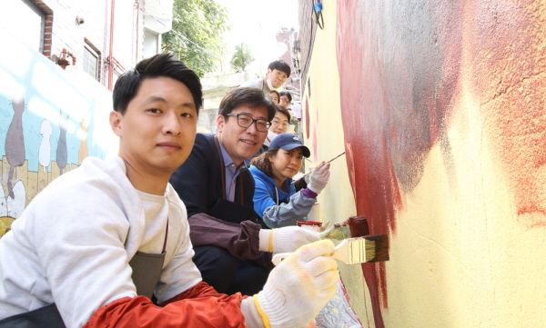 HDC현대산업개발 개발운영사업본부 임직원들이 18일 서울 용산구 이태원동 앤틱가구거리 일원에서 ‘HDC 사랑의 벽화그리기’ 사회공헌을 하며 기념촬영을 하고 있다. 