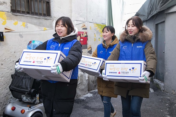 5일 삼성전자 임직원들이 서울 동대문구에 위치한 쪽방 밀집촌을 찾아 어르신들을 위한 생필품 세트를 나르고 있다.<사진=삼성전자>