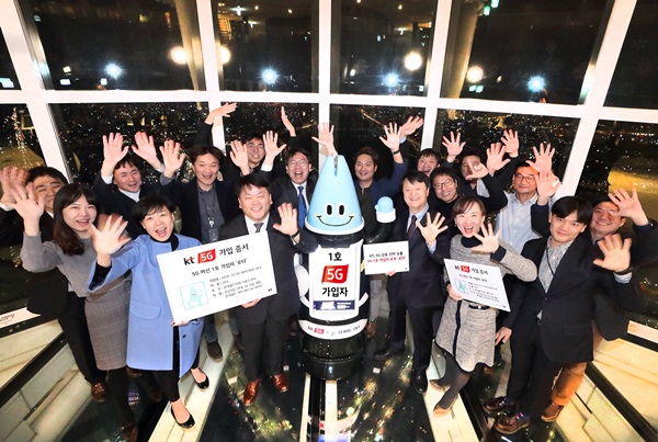 1일 KT 관계자들이 잠실 롯데월드타워 서울스카이 전망대에서 5G 머신 1호 가입자인 인공지능 로봇 ‘로타’와 기념촬영을 하고 있다.<사진=KT>
