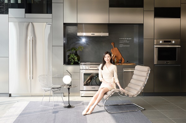 LG전자 모델이 놀의 대표 제품 중 하나인 엠알 체어(﻿MR Chaise)에 앉아 가전과 가구가 조화를 이루는 주방 공간을 소개하고 있다.<사진=LG전자>