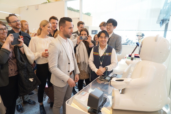 독일 다름슈타트 비즈니스스쿨 학생과 관계자들이 1일 서울 송파구 롯데월드타워에 있는 ‘세븐일레븐 시그니처’ 매장을 방문해 인공지능 결제로봇 ‘브니’를 체험하고 있다. 