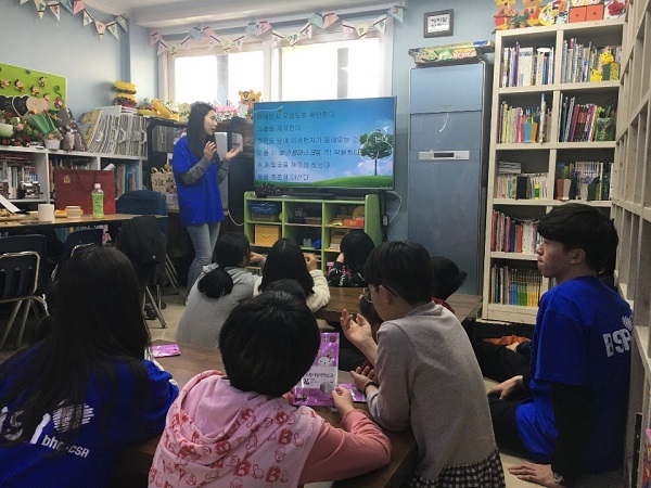 bhc치킨 해바라기 봉사단원이 서울 강북구 ‘사랑의 지역아동센터’에서 어린이들에게 미세먼지에 대해 교육하고 있다. <사진=bhc치킨>