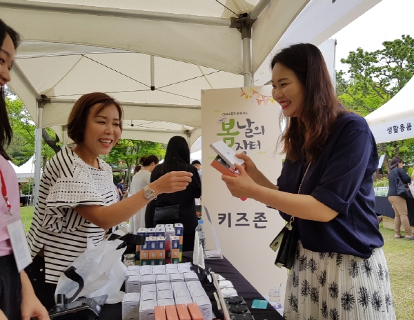 CJ ENM 오쇼핑부문이 25일 서울 서초구 방배동 사옥에서 개최한 ‘봄날의 장터’에서 한 고객이 뷰티용품을 구매하고 있다. <사진=CJ ENM>