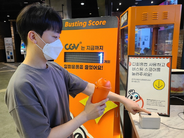 CJ CGV 관계자가 서울 강서구 CGV등촌에서 다회용 컵을 수령하고 버스팅 스코어를 누르는 모습을 신연하고 있다. <사진=CJ CGV>