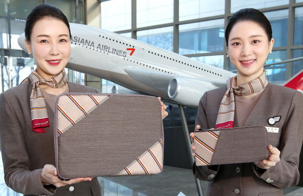 아시아나항공 승무원들이 회수한 유니폼을 이용해 제작한 업사이클링(Upcycling) 제품인 테블릿파우치를 소개하고 있다. <사진=아시아나항공>