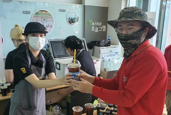 메가엠지씨커피 직원이 포항 수해복구 자원봉사자에게 커피를 전달하고 있다. <사진=메가엠지씨커피>