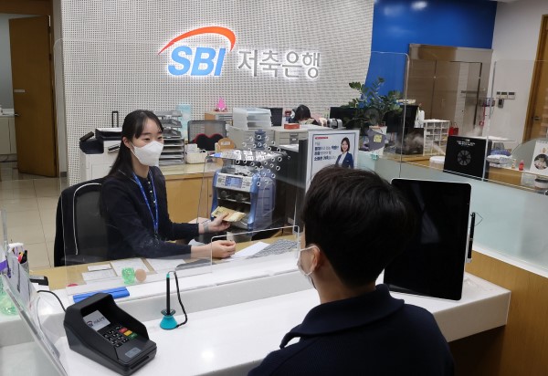 SBI저축은행 청담직원 직원이 소독된 지폐를 고객에게 전달하고 있다. <사진=SBI저축은행>