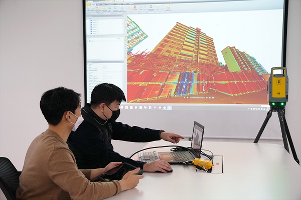 롯데건설 관계자가 3D 스캐너를 활용한 기존 아파트 모델링 데이터를 확인하고 있다. <사진=롯데건설>