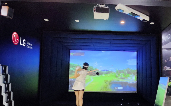 'LG 프로빔 레이저 4K’를 활용해 조성한 스크린골프 체험존에서 LG전자 모델이 스크린 골프를 즐기는 모습 <사진=LG전자>