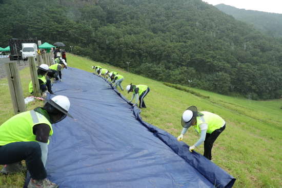 한국농어촌공사는 지난 23일 강도 높은 을지연습 비상훈련을 전남 담양군 담양호에서 실시했다고 밝혔다. 사진은 농어촌공사 관계자들이 저수지 누수를 막기 위해 천막을 덮는 모습. 